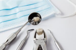 Extracted tooth surrounded by dental tools. 